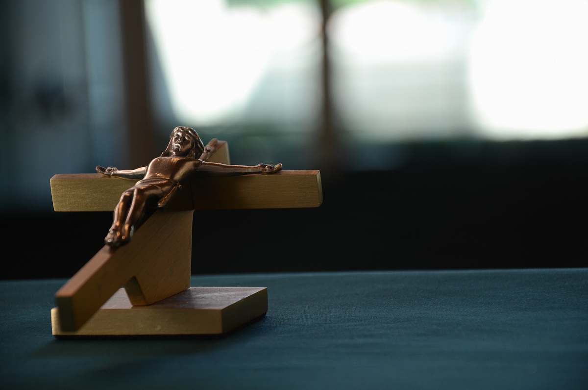 figurine brown wooden crucifixion on blue surface houston